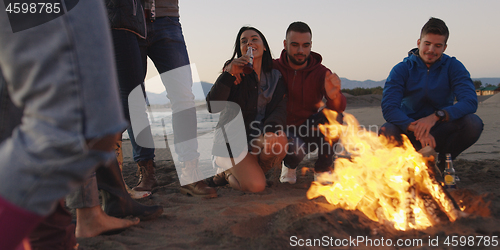 Image of Friends having fun at beach on autumn day