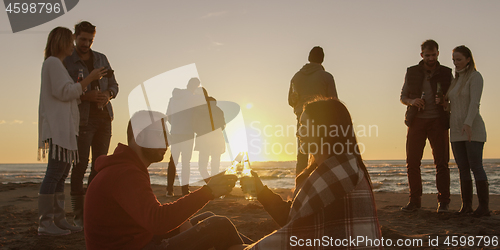 Image of Friends having fun at beach on autumn day