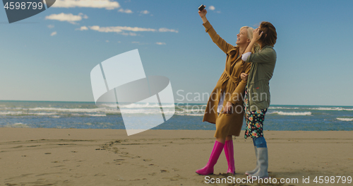 Image of Girls having time and taking selfie on a beach