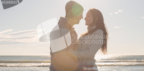 Image of Couple having fun on beautiful autumn day at beach