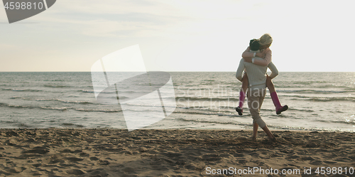 Image of Loving young couple on a beach at autumn on sunny day