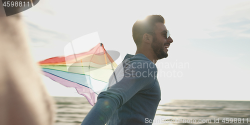 Image of Happy couple having fun with kite on beach