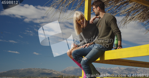 Image of Couple drinking beer together at the beach