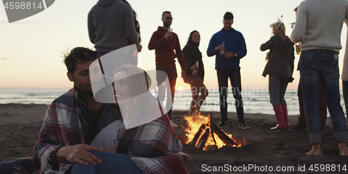 Image of Friends having fun at beach on autumn day