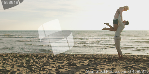 Image of Loving young couple on a beach at autumn on sunny day