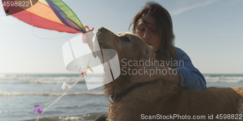 Image of Woman holding kite at beach on autumn day