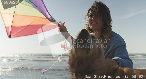 Image of Woman holding kite at beach on autumn day