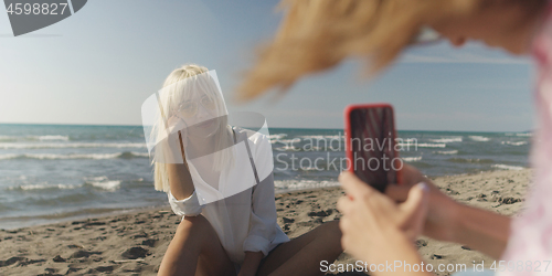 Image of Two girl friends having fun photographing each other on vecation