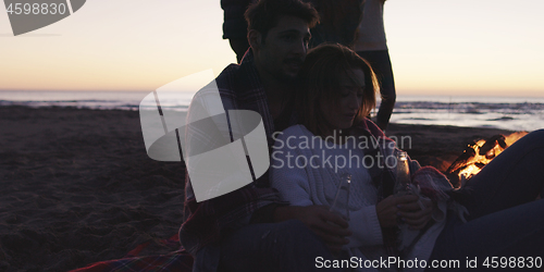 Image of Friends having fun at beach on autumn day