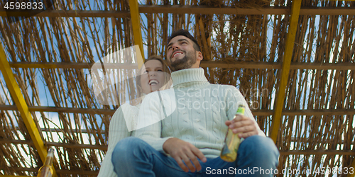 Image of Couple drinking beer together at the beach