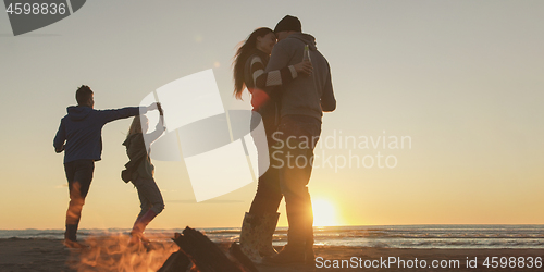 Image of Friends having fun at beach on autumn day