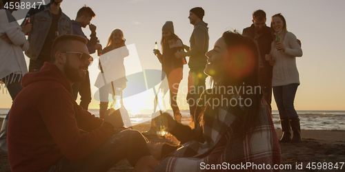 Image of Friends having fun at beach on autumn day