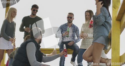 Image of Group of friends having fun on autumn day at beach