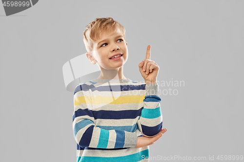 Image of little boy in striped pullover pointing finger up