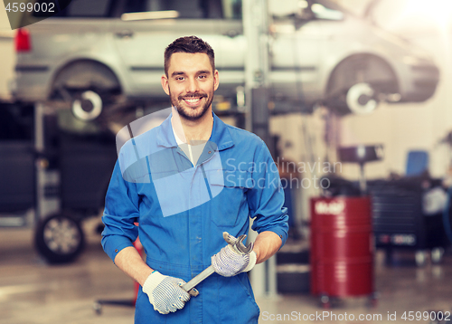 Image of auto mechanic or smith with wrench at car workshop