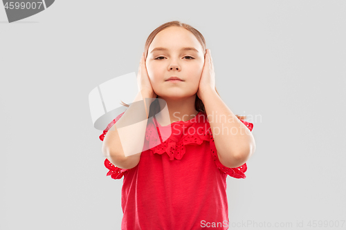 Image of beautiful girl in red shirt closing ears by hands