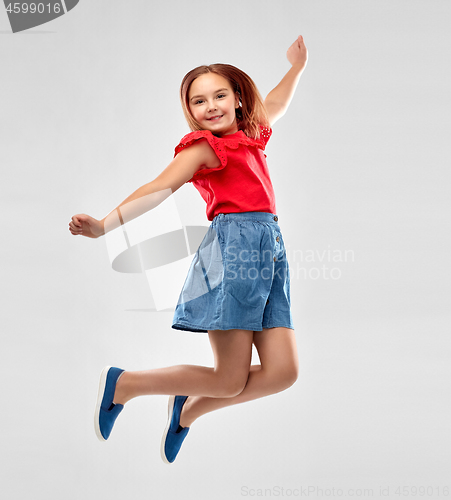 Image of happy smiling girl in red shirt and skirt jumping