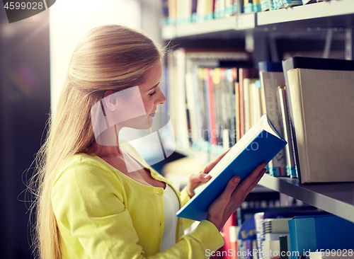 Image of high school student girl reading book at library