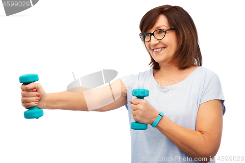 Image of smiling senior woman with dumbbells exercising