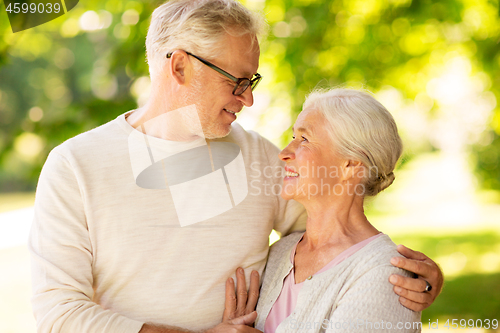 Image of happy senior couple hugging at summer park