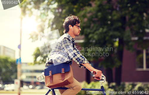 Image of young hipster man with bag riding fixed gear bike