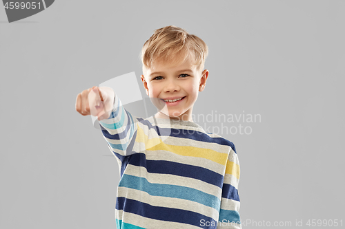 Image of smiling boy in striped pullover pointing finger