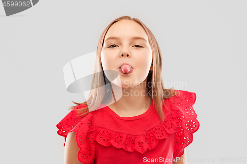 Image of beautiful girl in red shirt showing her tongue