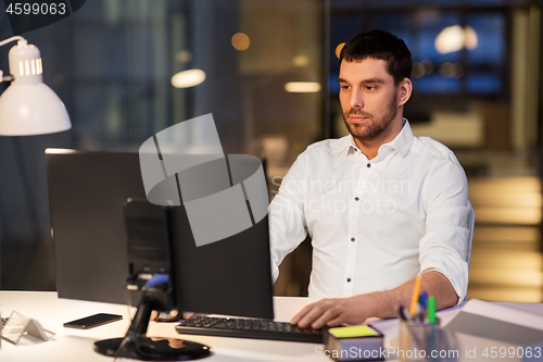 Image of businessman with computer working at night office