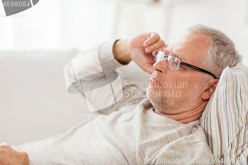 Image of close up of senior man in glasses thinking at home