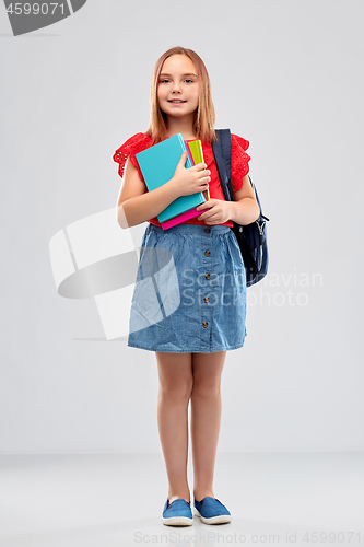 Image of smiling student girl with books and bag