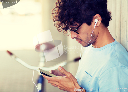 Image of man with smartphon, earphones and bicycle