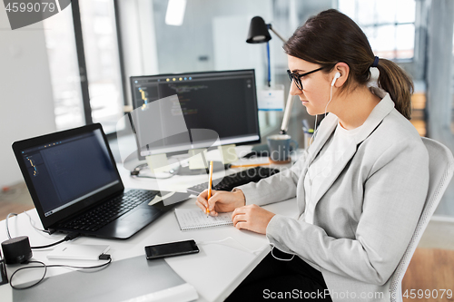 Image of businesswoman with notebook working at office