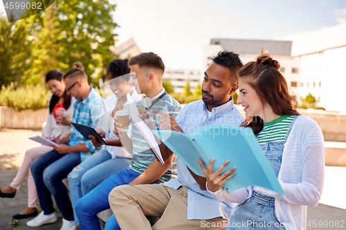 Image of group of happy students with notebooks and drinks