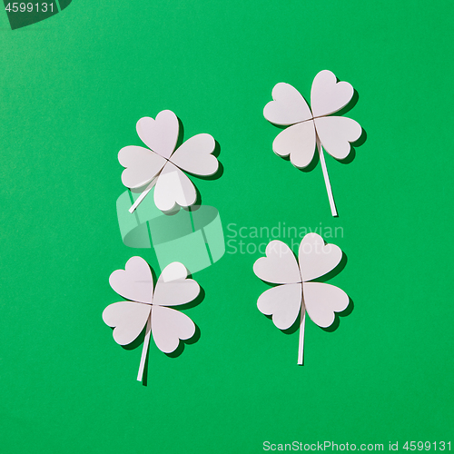 Image of Four handmade shamrock\'s leaves with shadows.