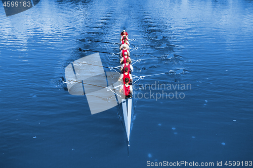 Image of Boat coxed eight Rowers rowing on the blue lake. Classic Blue Pa