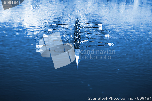 Image of Boat coxed eight Rowers rowing on the tranquil lake. Classic Blu