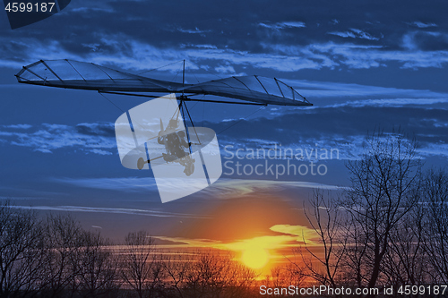 Image of The motorized hang glider fly in the sunset. Classic Blue Panton