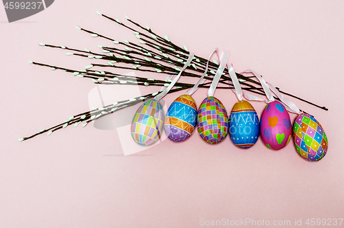 Image of Paper colorful Easter eggs lie on a gently pink background. Easter concept.