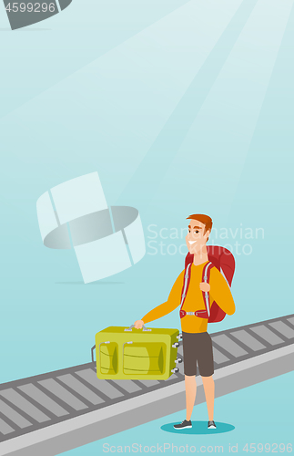 Image of Man picking up suitcase from conveyor belt.