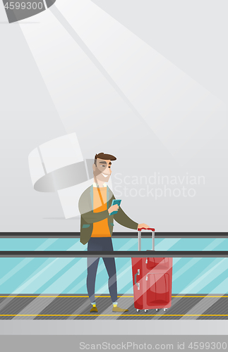 Image of Man using smartphone on escalator at the airport.