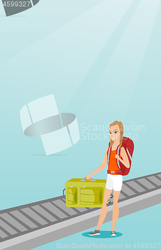 Image of Woman picking up suitcase from conveyor belt.