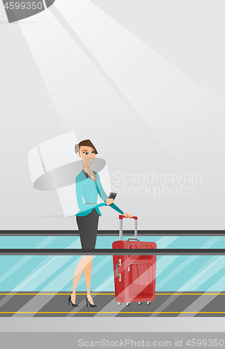 Image of Woman using smartphone on escalator at the airport