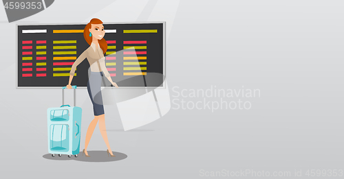 Image of Caucasian woman walking with suitcase at airport.