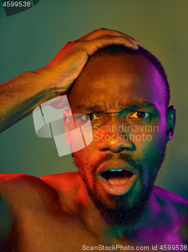 Image of Close up portrait of a young naked african man looking at camera indoors