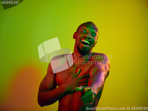 Image of Close up portrait of a young naked african man looking at camera indoors