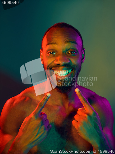 Image of Close up portrait of a young naked african man looking at camera indoors