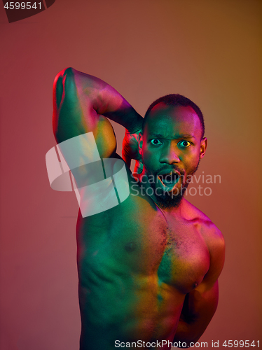 Image of Close up portrait of a young naked african man looking at camera indoors