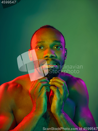 Image of Close up portrait of a young naked african man looking at camera indoors