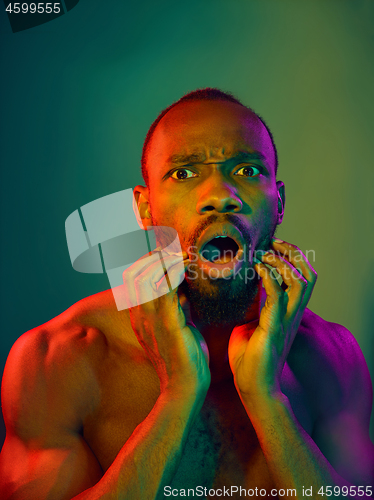 Image of Close up portrait of a young naked african man looking at camera indoors