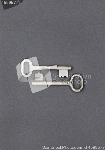 Image of Two keys on gray paper background, close up